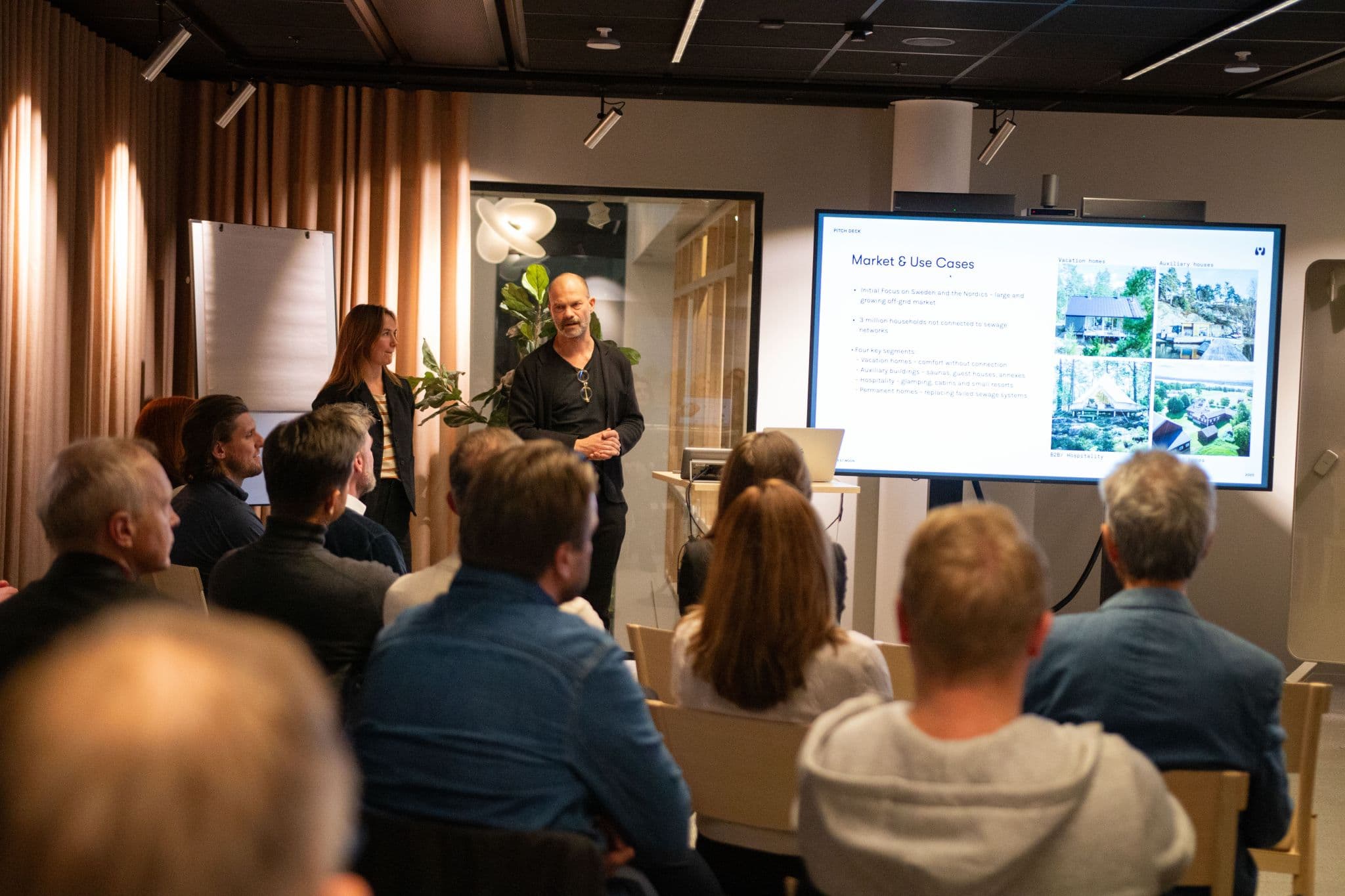 Presentatör visar slide om marknad och användningsfall med Harvest Moon-logotyp för publik